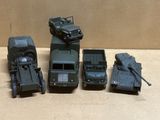quatre véhicules militaires miniatures et une jeep posés sur une table