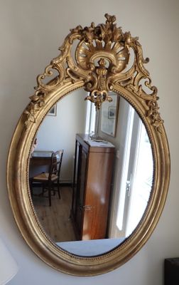 un miroir accroché au mur à côté d'une lampe