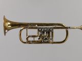 a brass trumpet that is sitting on a white surface