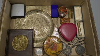 une boîte remplie d'objets divers, notamment une horloge, un livre et d'autres objets