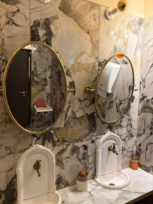 une salle de bains en marbre avec deux lavabos et un miroir
