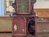 une armoire en bois surmontée d'un miroir, dans une pièce