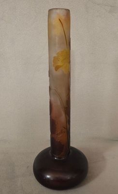 un vase en verre orné d'une fleur, posé sur un socle