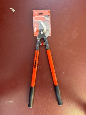 an orange pliers with black handles on a brown surface