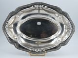 an antique silver plate with a decorative design on a stand