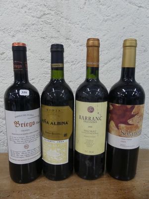 quatre bouteilles de vin sont alignées sur une table en bois
