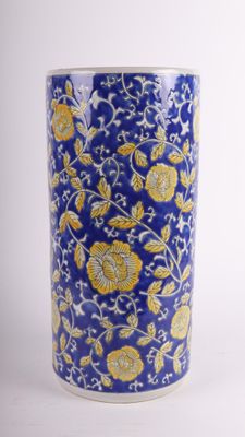 un vase bleu orné de fleurs jaunes et blanches