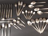 a lot of spoons and forks laid out on a table