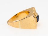 an image of a gold ring with a blue stone in the center