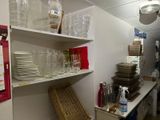 many plates and glasses on the shelves in the kitchen