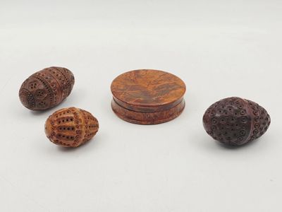 un ensemble de quatre objets en bois sculpté posés sur une surface blanche