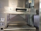 a large stainless steel grill in the kitchen with utensils