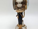 a clock that is sitting on a pedestal on a white surface