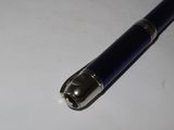 a blue pen that is laying on a white surface