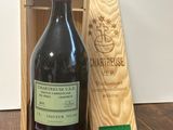 une bouteille de vin posée sur une table à côté d'une caisse en bois