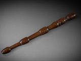 an old wooden stick with a wooden handle sitting on a table