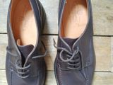une paire de chaussures en cuir marron à lacets posée sur un parquet
