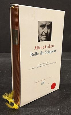 the book is sitting on a table with a yellow feather