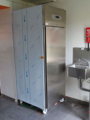 un évier en inox et un réfrigérateur en inox dans des toilettes publiques