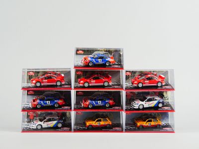 six petites voitures dans une vitrine posée sur une surface blanche