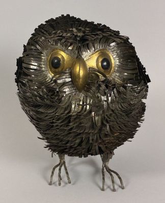 a metal sculpture of an owl with big eyes