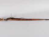 a close up of a wooden stick with a feather on it