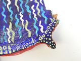 a blue and red fish shaped dish on a white table