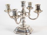 a silver plated candelab with four candles on a stand