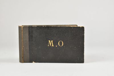 un livre noir orné de lettres dorées, posé sur une surface blanche