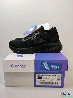 une paire de chaussures de course noires posée sur une boîte