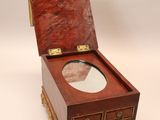 a small wooden box with a mirror in it
