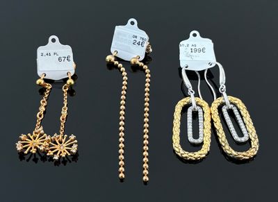 trois paires de boucles d'oreilles en or et en argent sur un fond noir