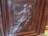 carvings on the side of a wooden cabinet in a room