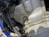 a close up of a motorcycle engine with a blue handlebar