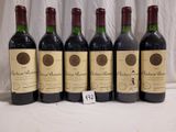 six bottles of red wine are lined up on a table