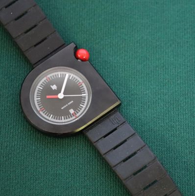 a black watch with a red dot on the face