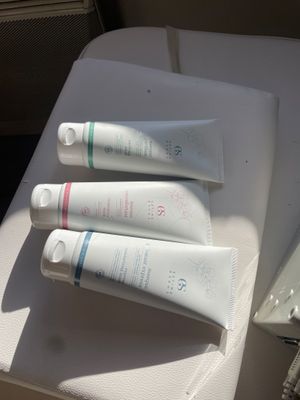 three tubes of toothpaste sitting on a table next to a mirror