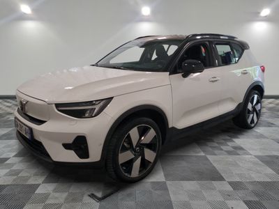 Le SUV Volvo blanc est garé sur un sol à damier.