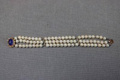 un gros plan sur un bracelet orné de perles et d'une pierre bleue