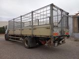 a truck with a cage on the back parked in a parking lot