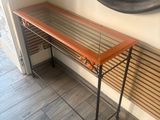 a wooden table with a mirror on it in a room