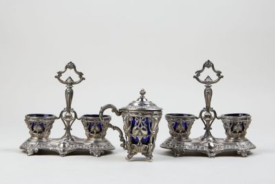 four pieces of silver and blue glass on a white surface