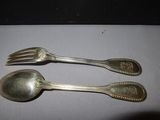 two spoons and a fork sitting on a table