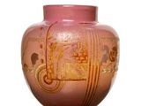 un vase rose orné d'un motif doré