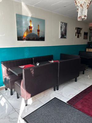 a room with a table, couches, and a chandelier in it