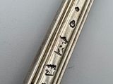 a silver spoon with writing on it sitting on a table