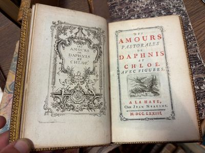 quelqu'un tient un livre ouvert sur une table en bois
