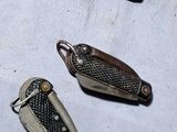 several small metal objects on a white surface with a small metal object in the middle of them