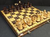 a wooden chess board with chess pieces on top of it