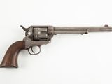 un vieux revolver avec un manche en bois sur fond blanc